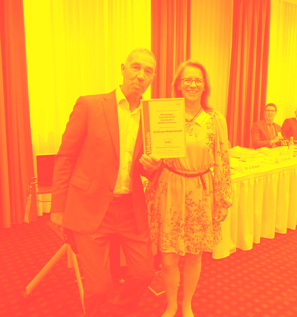 Mann und Frau halten eine Jubiläumsurkunde