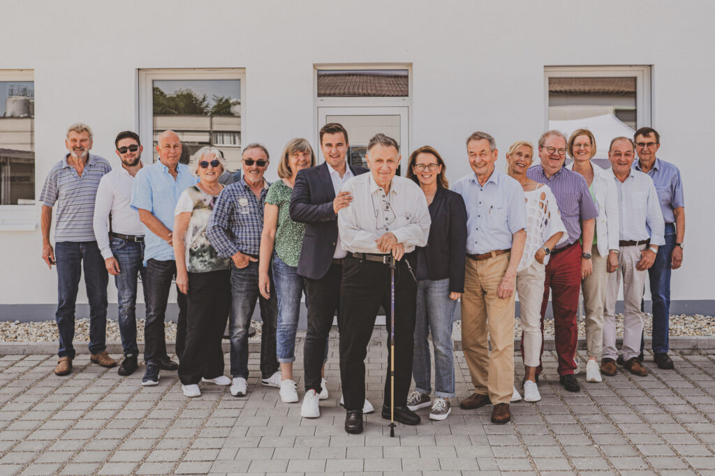 Gruppe von Menschen vor einem Gebäude im Freien.
