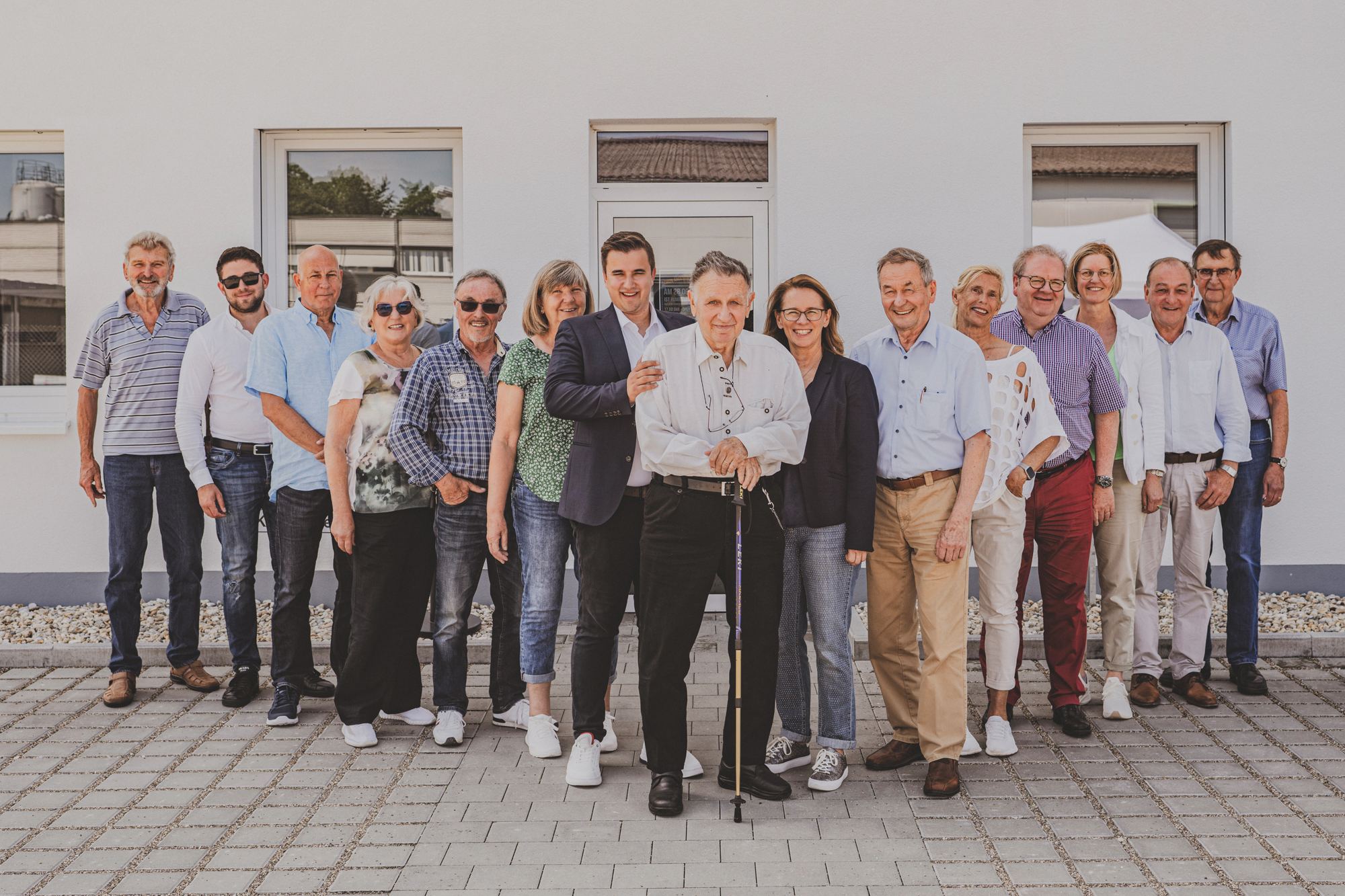 Gruppe von Menschen vor einem Gebäude im Freien.